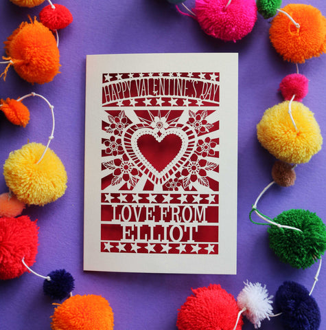 A personalised paper cut Valentine's card with a cut out heart surrounded by flowers.