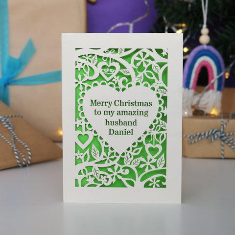 A personalised Christmas card. Card has text inside a heart shape, with a border of hearts, flowers and snowflakes. - A5 / Cream / Bright Green