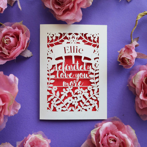 A laser cut Valentine's card that says "I definitely love you more"