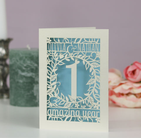 A paper anniversary card for a first anniversary. Card is laser cut with "Olivia & Nathan, 1 amazing year" - 