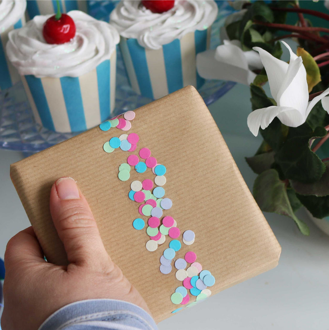 easy gift wrap hack involving a hole punch and sellotape