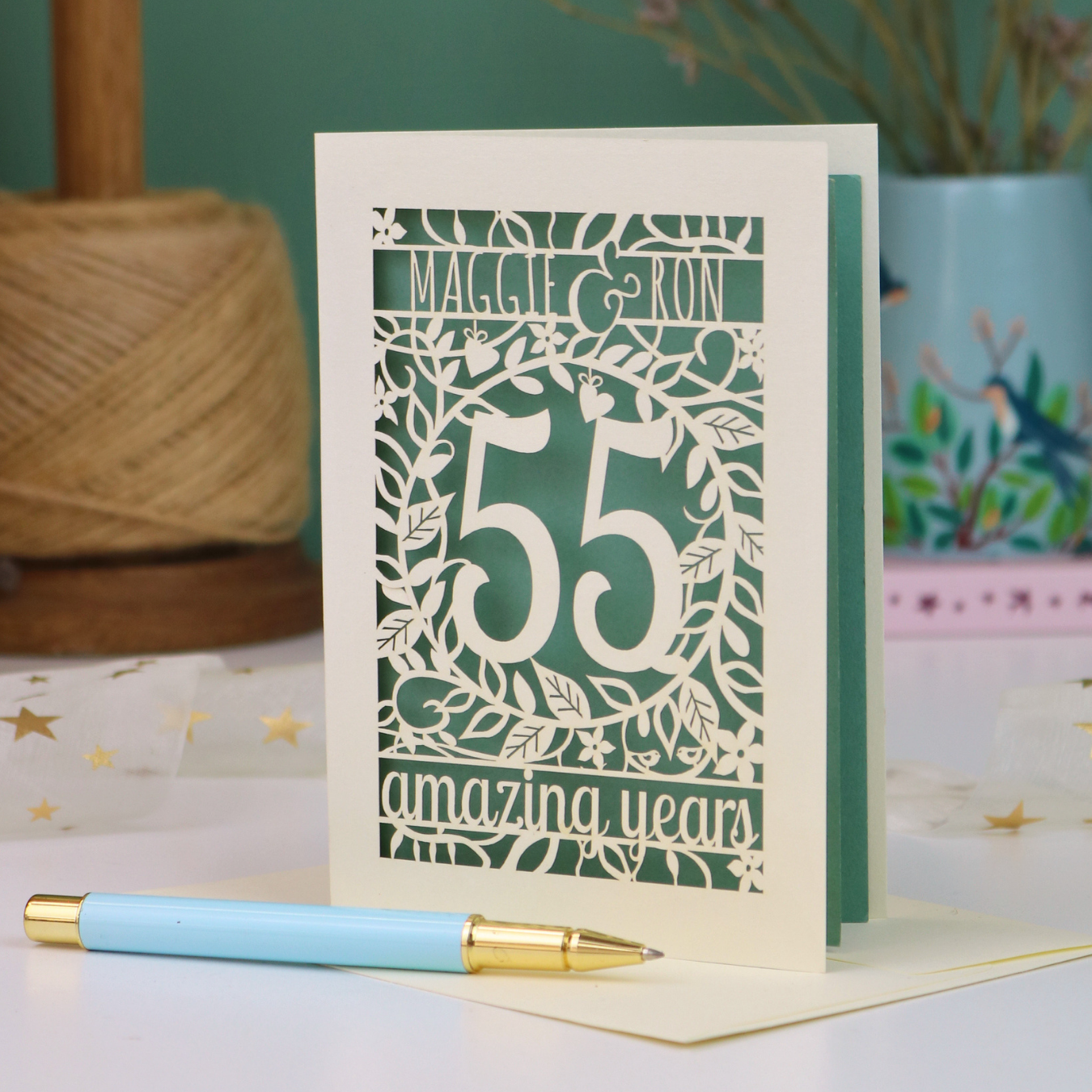 A cream 55th anniversary card with emerald laser-cut floral details
