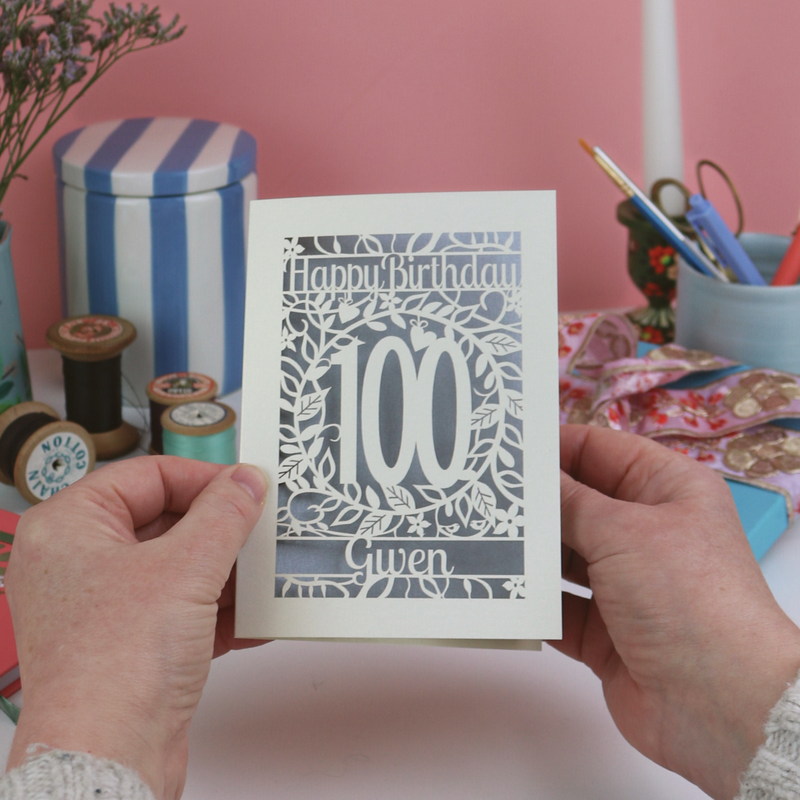 Hands holding a laser cut 100th birthday card