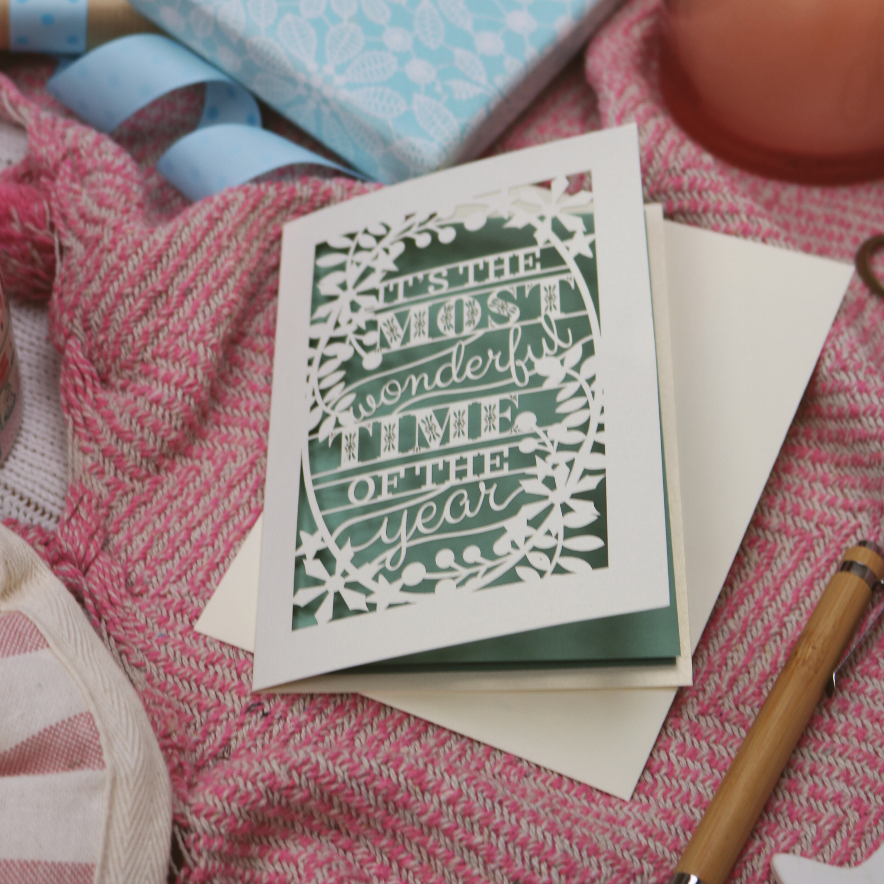 A laser cut Christmas card on pink background