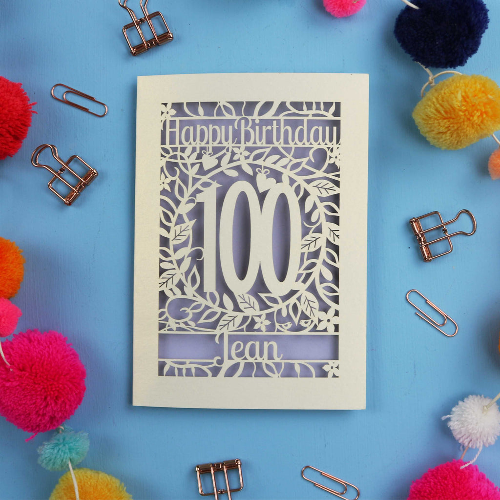 Laser cut 100th birthday card with decorative elements on a blue background