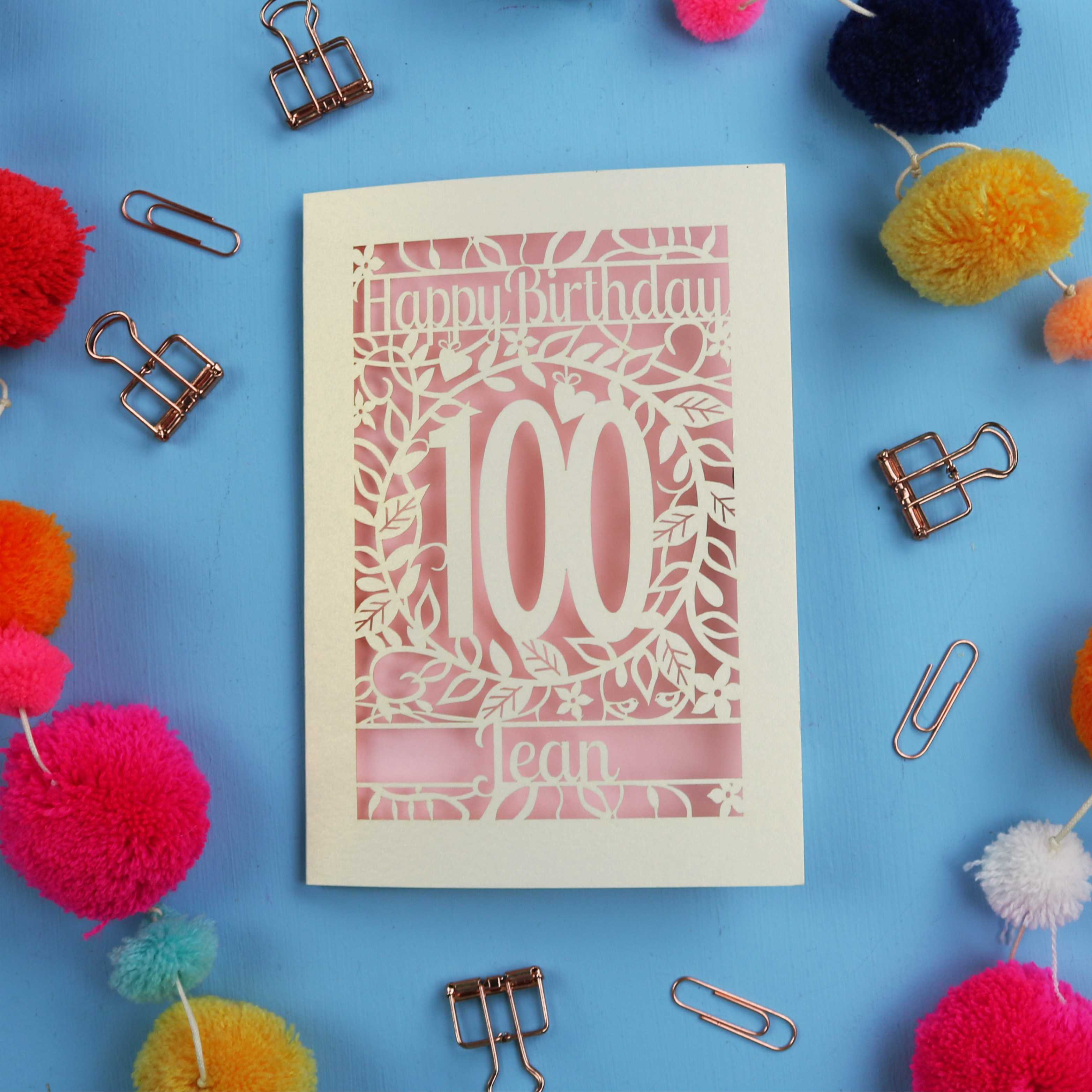 Laser cut 100th birthday card with decorative elements on a blue background