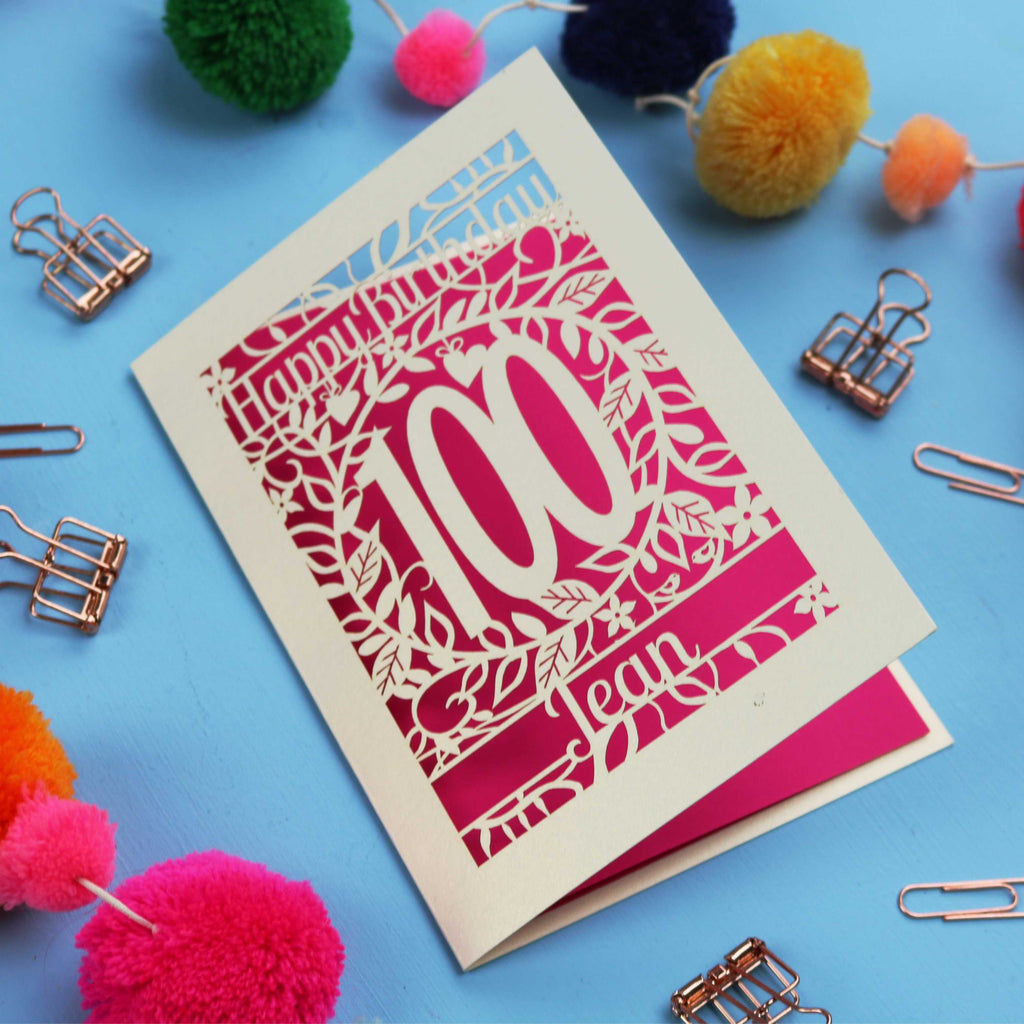 Laser cut 100th birthday card with decorative elements on a blue background