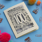 Laser cut 100th birthday card with decorative elements on a blue background