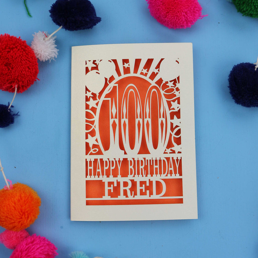 Special 100th Birthday card with 'Happy Birthday Fred' text on a blue background with colourful pom-poms.