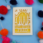 100th Birthday card with 'Happy Birthday Fred' text on a blue background with colourful pom-poms.