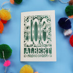 Decorative paper cut out 100th birthday card with '100 Albert' on a blue background with colourful pom-poms.