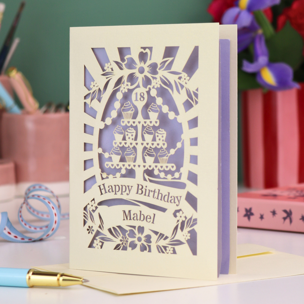 Laser-cut 18th birthday card with decorative elements on a desk with stationery items.