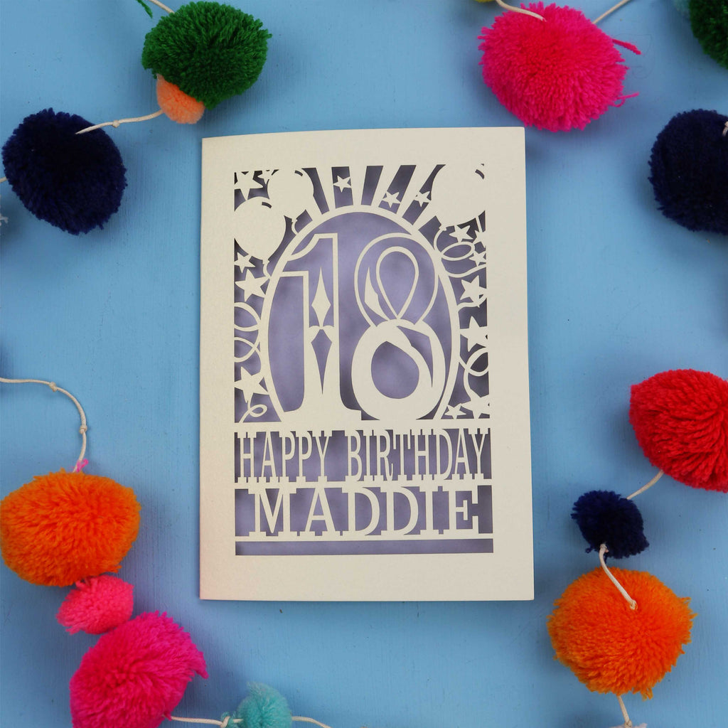 18th Birthday card with 'Happy Birthday Maddie' on a blue background with colourful pom-poms