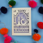 18th Birthday card with 'Happy Birthday Maddie' on a blue background with colourful pom-poms