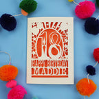 18th Birthday card with 'Happy Birthday Maddie' on a blue background with colourful pom-poms