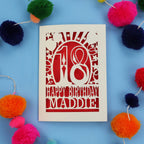 18th Birthday card with 'Happy Birthday Maddie' on a blue background with colourful pom-poms