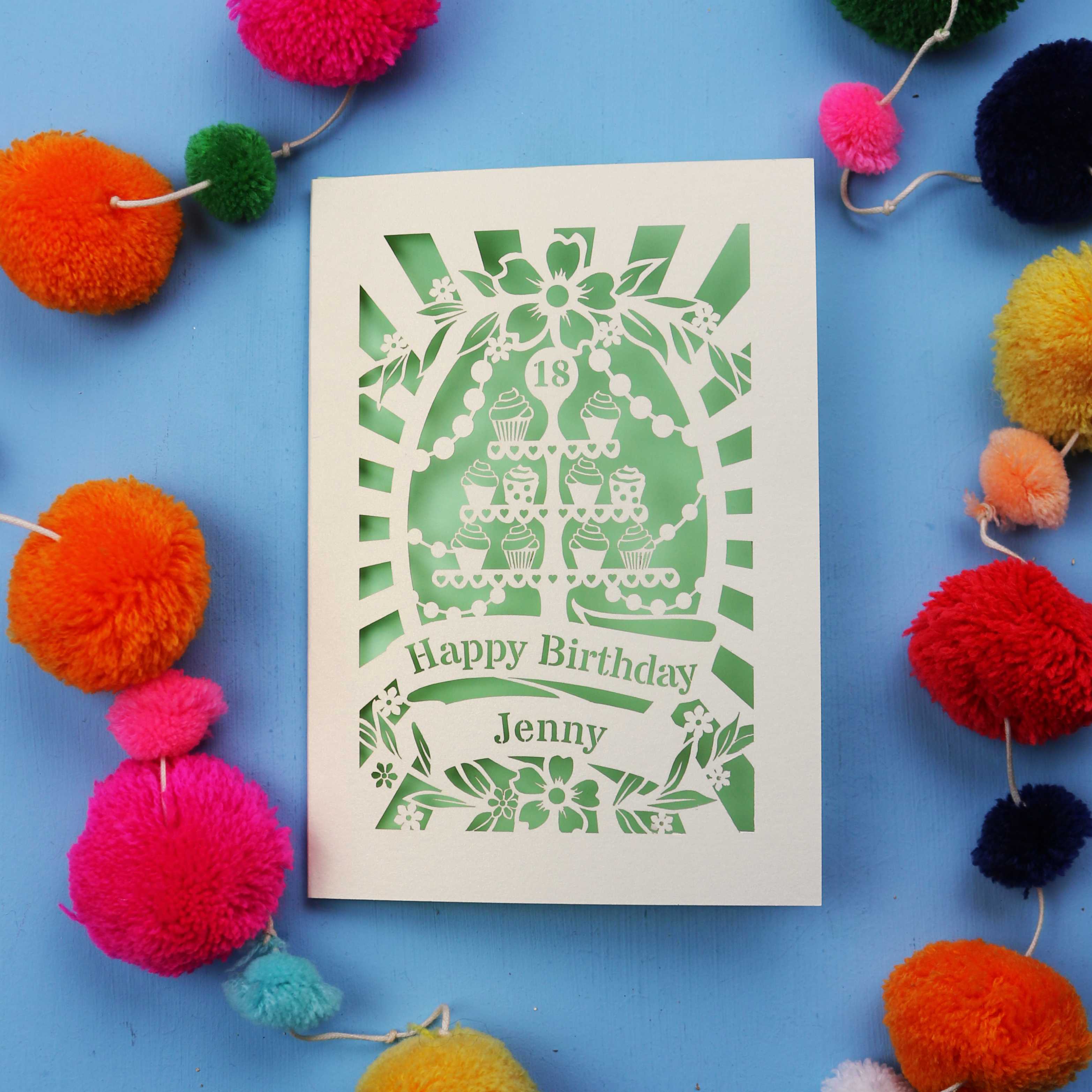 Laser-cut 18th birthday card with colourful pom-poms on a blue background