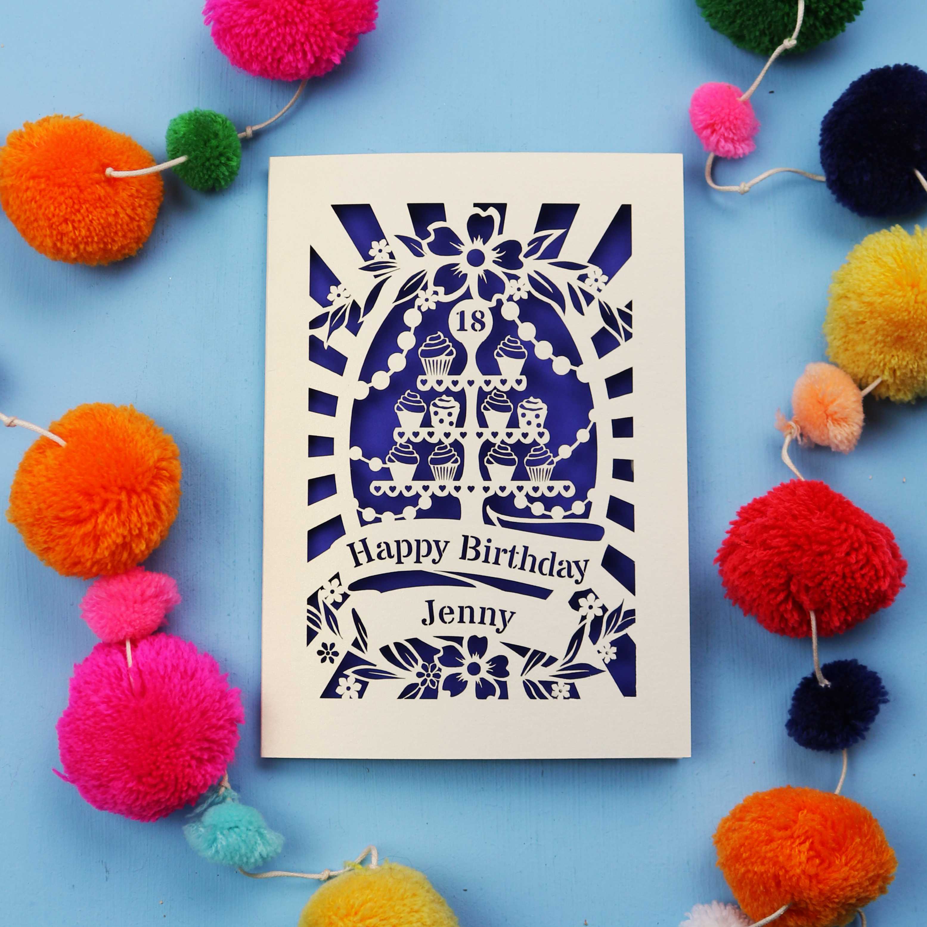 Laser-cut 18th birthday card with colourful pom-poms on a blue background