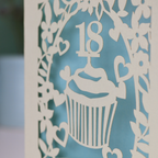 Personalised laser cut 18th birthday card with cupcake design and '18 Nicki' text on a light background.
