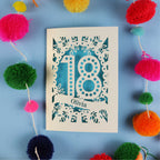 Decorative 18th birthday card with '18' and 'Olivia' on a blue background with colourful pom-poms.