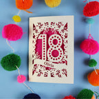Decorative 18th birthday card with '18' and 'Olivia' on a blue background with colourful pom-poms.