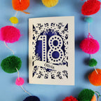 Decorative 18th birthday card with '18' and 'Olivia' on a blue background with colourful pom-poms.