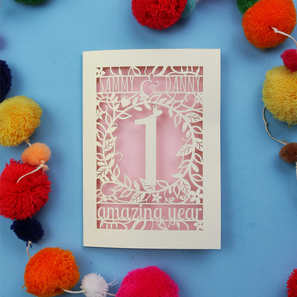 First wedding anniversary Card with cut-out design on a blue background with colourful pom-poms