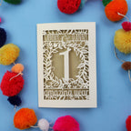 Paper wedding anniversary Card with cut-out design on a blue background with colourful pom-poms
