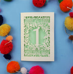 1st anniversary Card with cut-out design on a blue background with colourful pom-poms