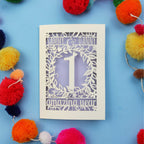 1st wedding anniversary Card with cut-out design on a blue background with colourful pom-poms