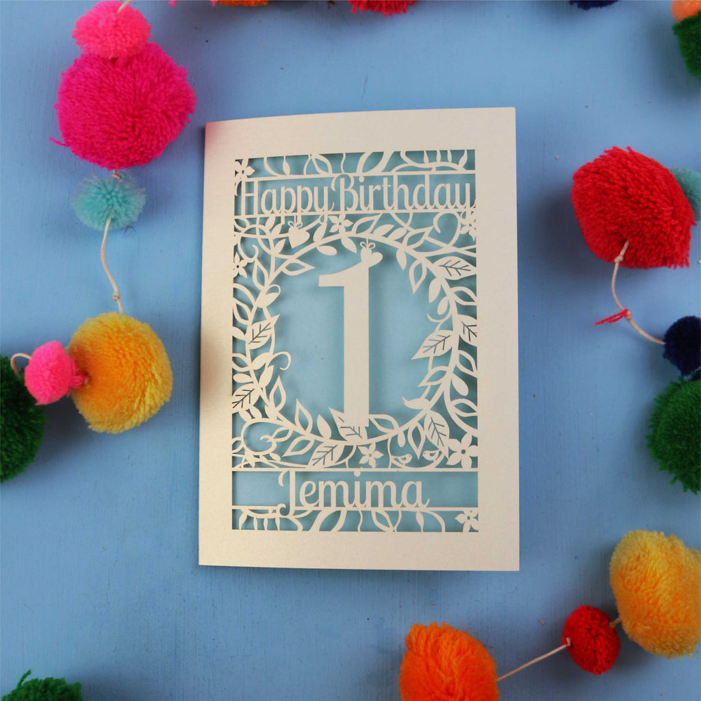 Personalised 1st birthday card with decorative elements on a blue background