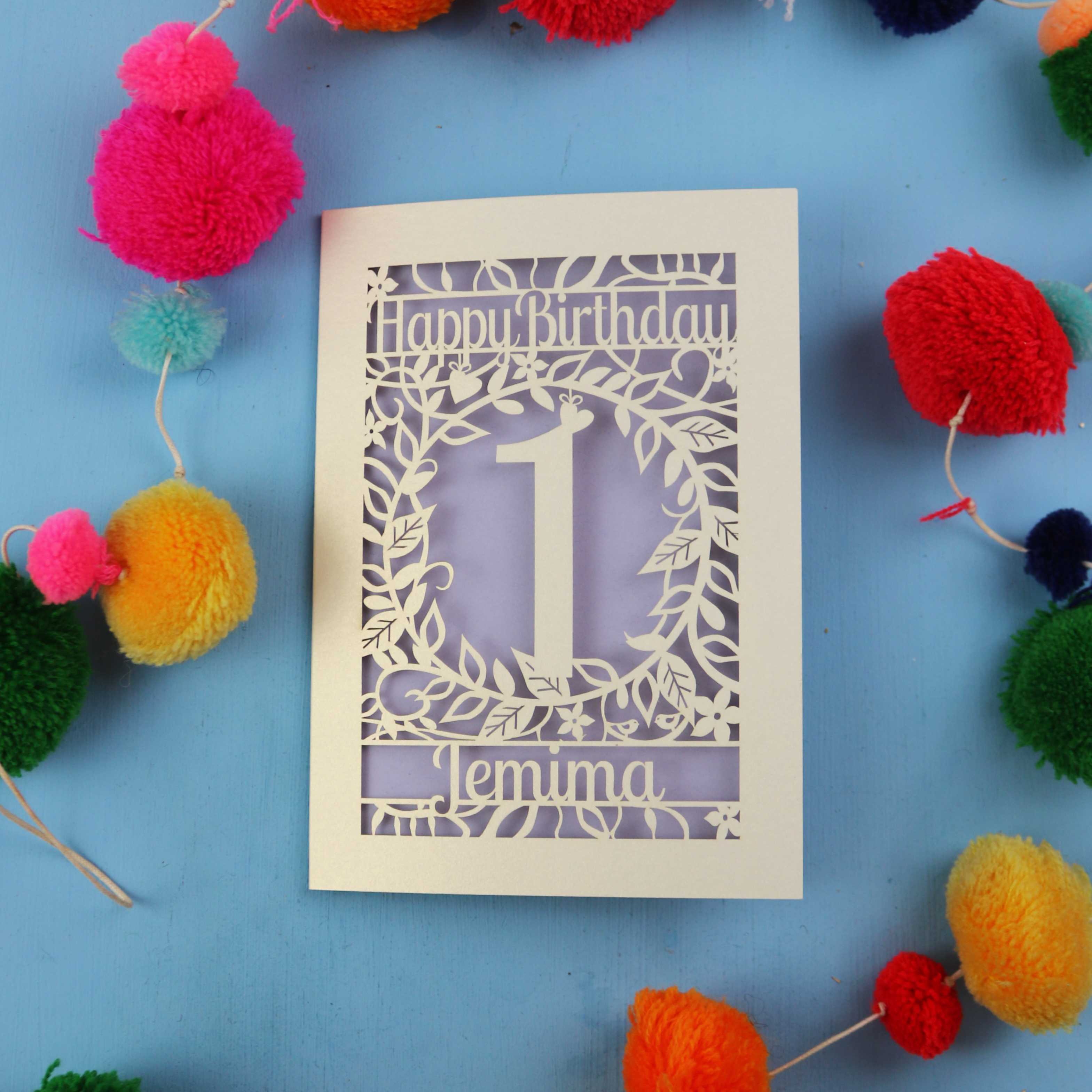 Personalised 1st birthday card with decorative elements on a blue background