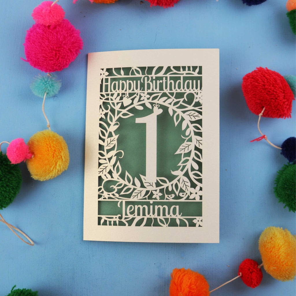 Personalised 1st birthday card with decorative elements on a blue background