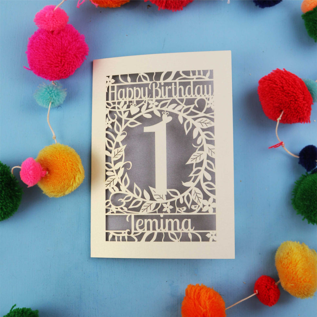 Personalised 1st birthday card with decorative elements on a blue background