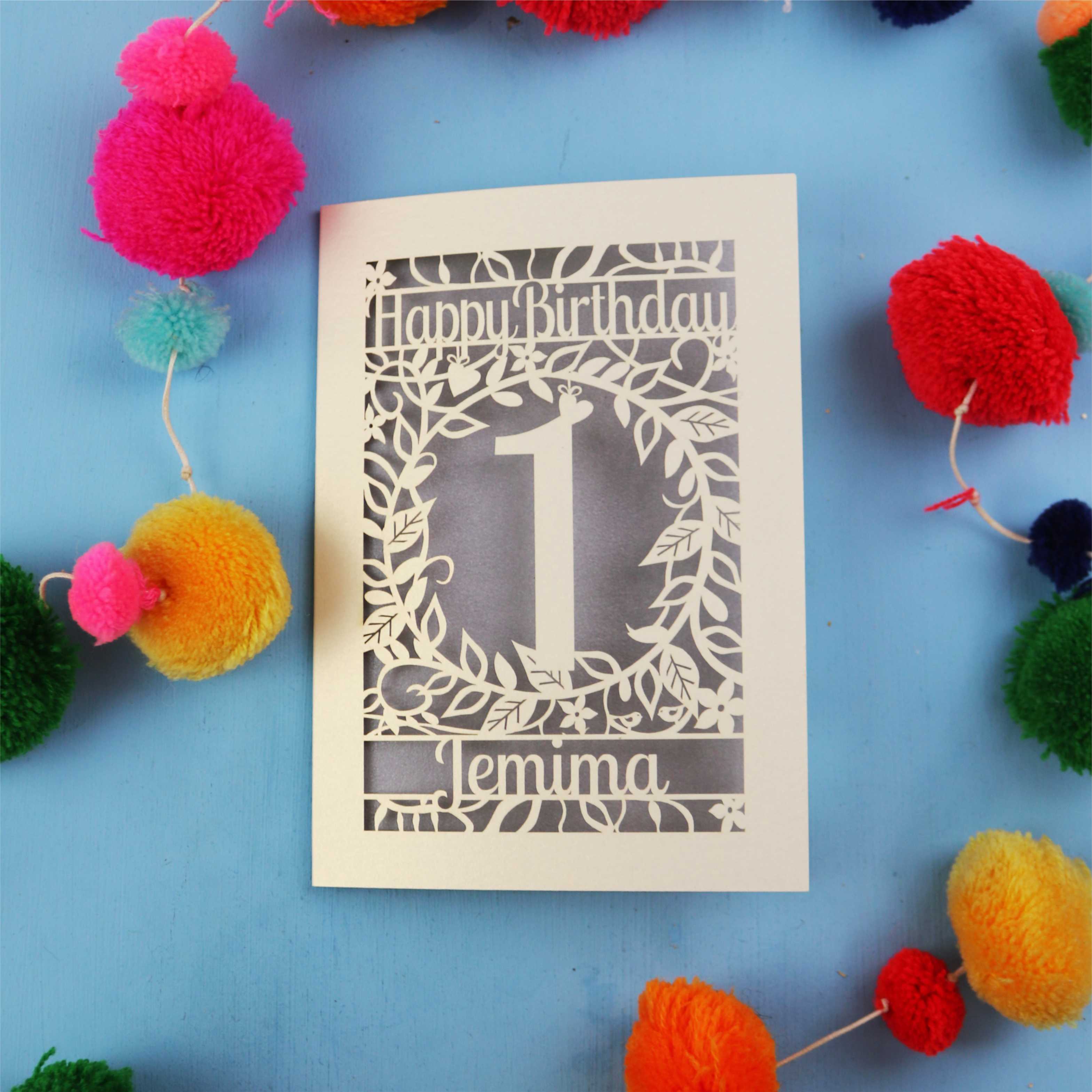 Personalised 1st birthday card with decorative elements on a blue background