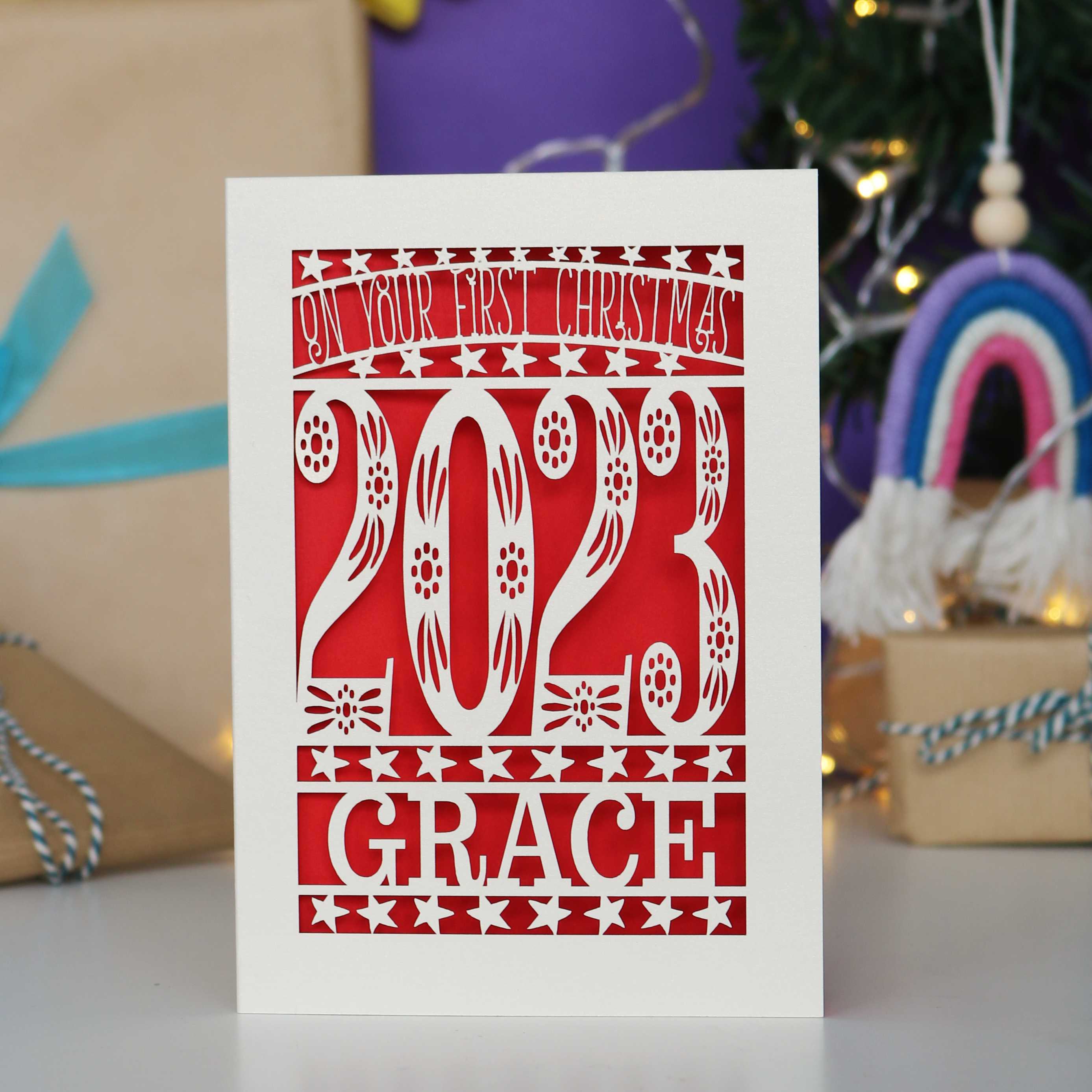 A lovely bright red and cream card showing the current year and the name of the baby, for their first Christmas.