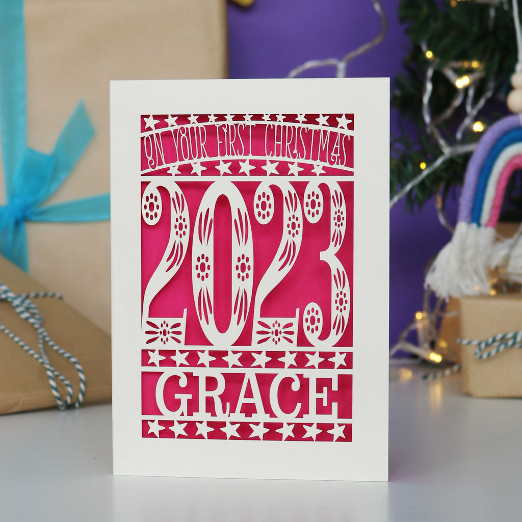 A striking bright pink and cream papercut card for a baby's first Christmas.