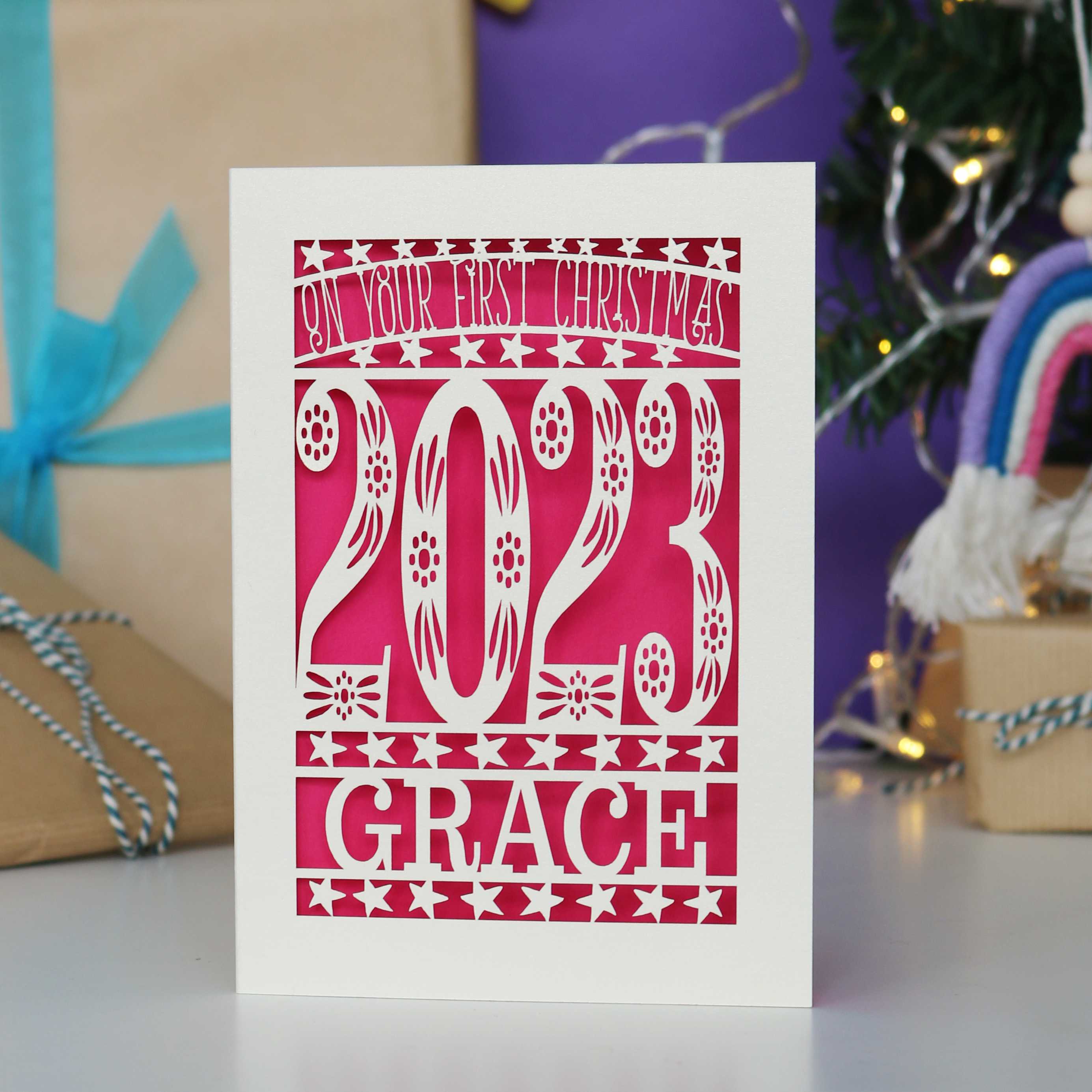 A striking bright pink and cream papercut card for a baby's first Christmas.