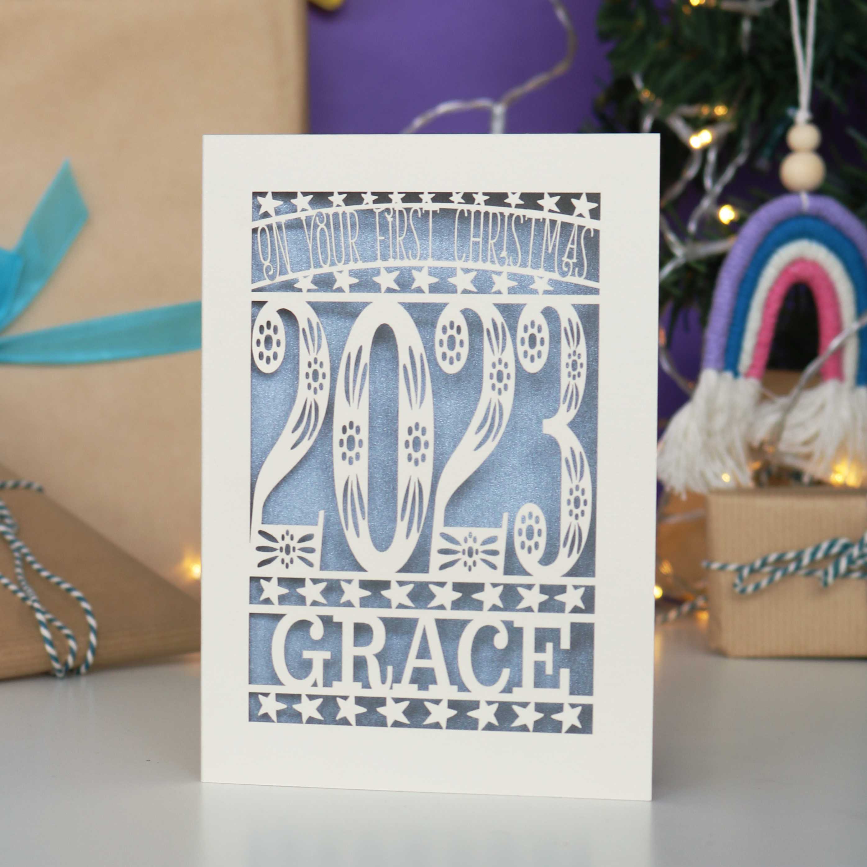 Baby's first Christmas card in cream with silver insert and showing the current year and baby's name.