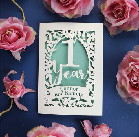 A first anniversary card personalised with the names of the couple. Card is cream and cut away to reveal a sage green paper insert.  - A5 (large); / Sage