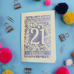 A Laser Cut 21st Birthday card with 'Happy Birthday' and age '21' on a blue background with decorative items.
