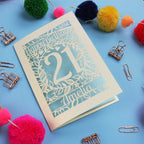 A Laser Cut 21st Birthday card with 'Happy Birthday' and age '21' on a blue background with decorative items.