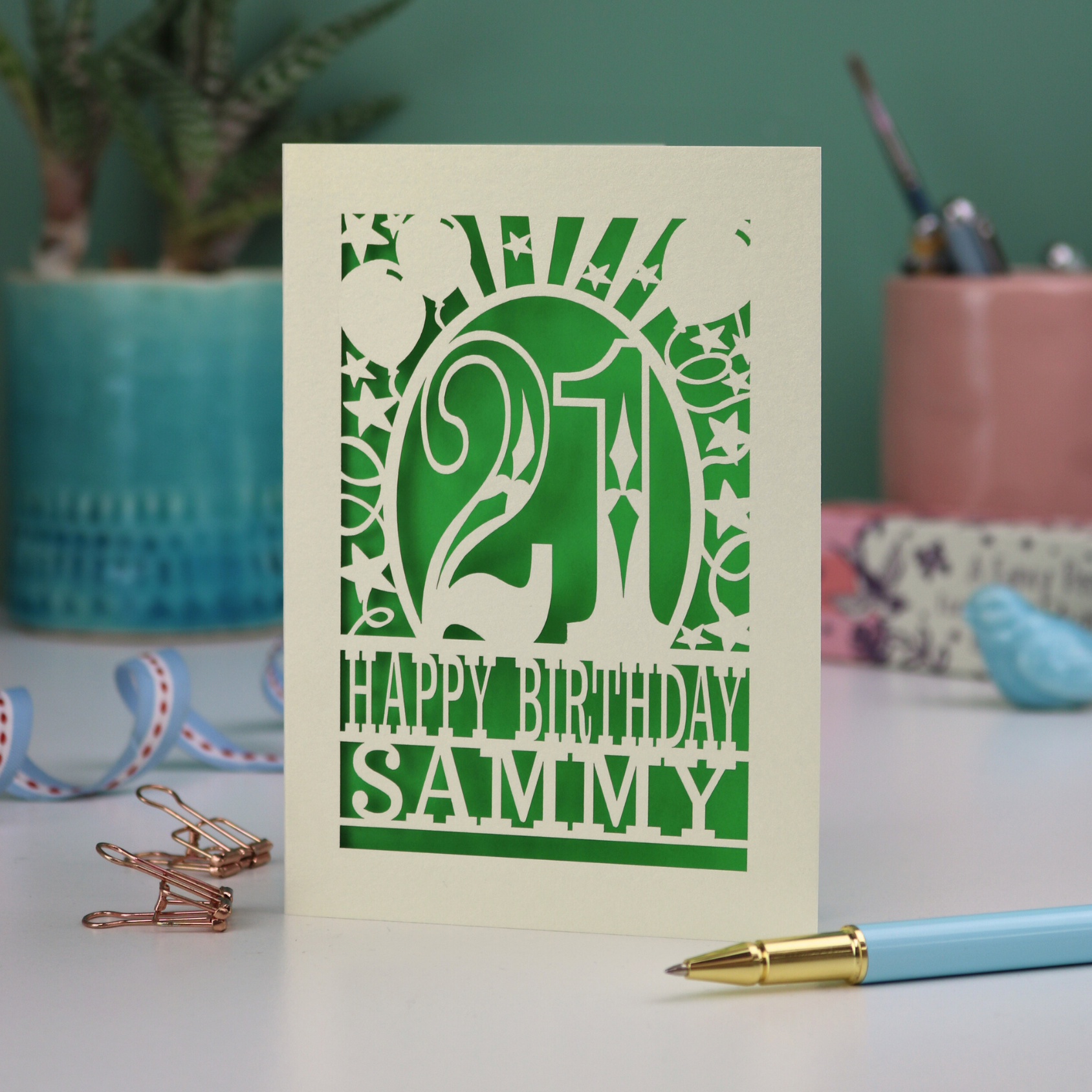 Cream and Green laser cut 21st birthday card with 'Happy Birthday Sammy' on a desk with stationery items.