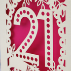 21st birthday card close up detail- a Laser cut number '21' with decorative elements on a shocking pink background
