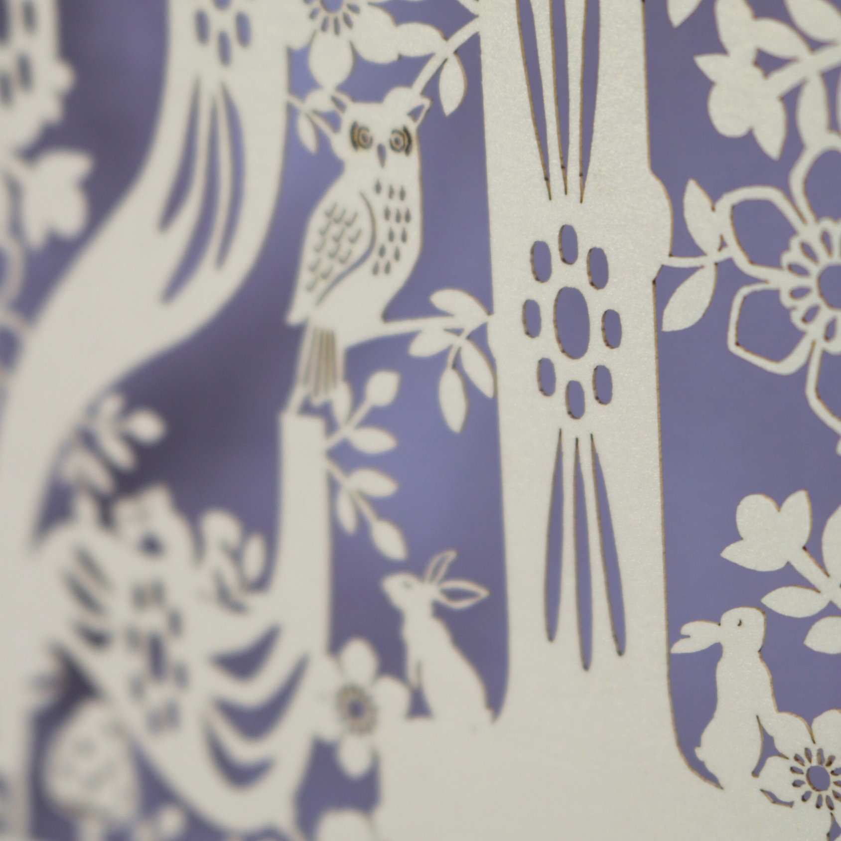 Close up photo of laser cut 21st birthday card, showing a tiny laser cut owl and rabbits