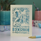 A cut out 21st birthday card, personalised with the name "Rosie", with the number 21 in the centre and woodland theme design, including tiny rabbits, a squirrel, owl, toadstools, leaves and flowers.