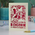 A cut out 21st birthday card, personalised with the name "Rosie", with the number 21 in the centre and woodland theme design, including tiny rabbits, a squirrel, owl, toadstools, leaves and flowers.