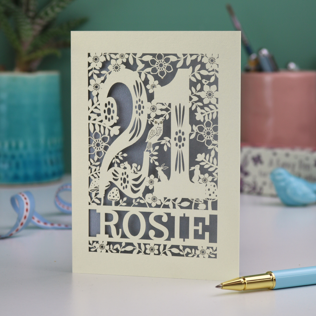 A paper cut 21st birthday card, personalised with the name "Rosie", with the number 21 in the centre and woodland theme design