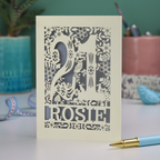 A paper cut 21st birthday card, personalised with the name "Rosie", with the number 21 in the centre and woodland theme design
