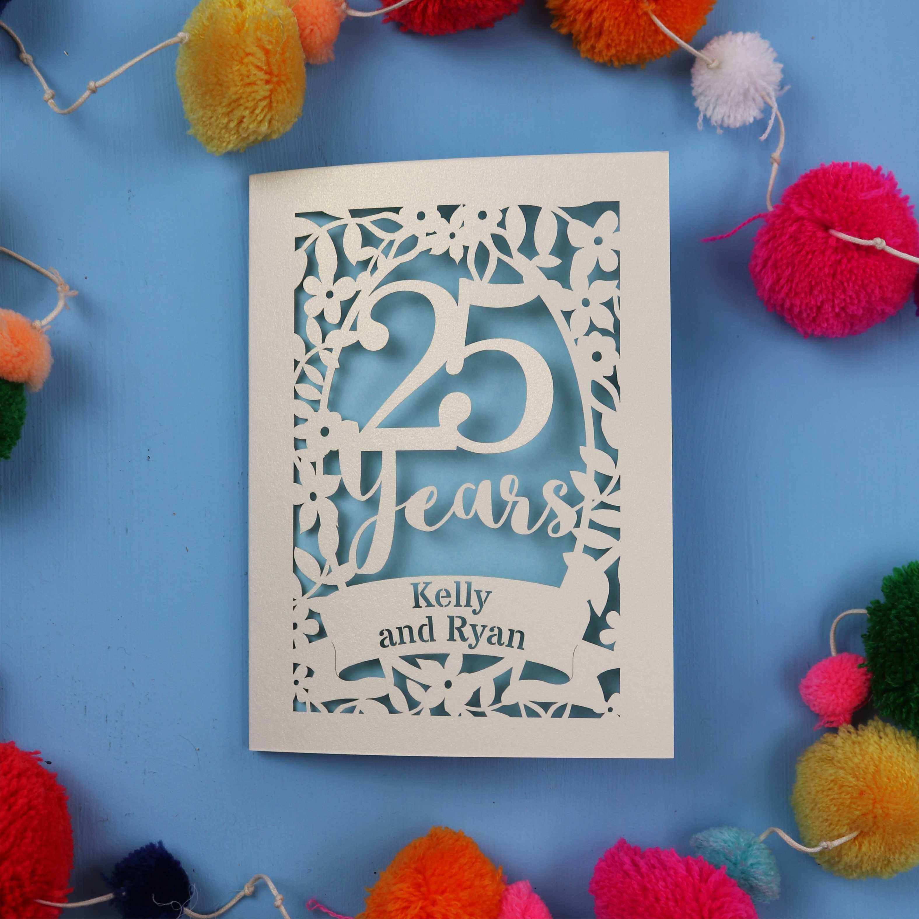 25th Wedding Anniversary Card with '25 Years' and 'Kelly and Ryan' text on a blue background with colourful pom-poms.